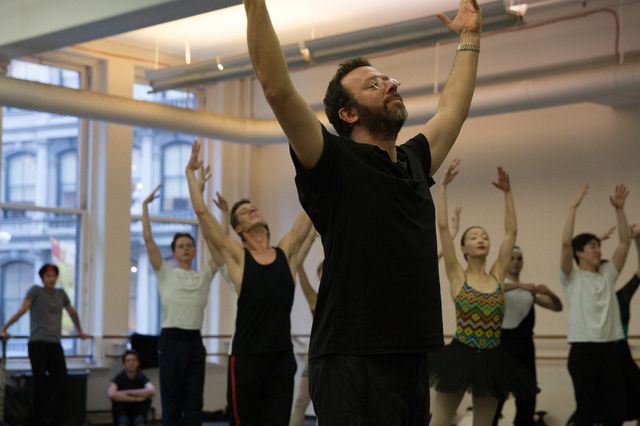 A choreographer working with dancers in a studio